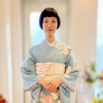 上品な水色の訪問着を着た女性が結婚式列席の支度を整えている様子