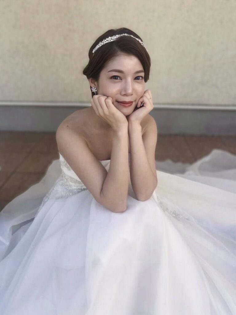 ウェディングドレスを着た花嫁が微笑む、ブライダルヘアメイク仕上がりの写真