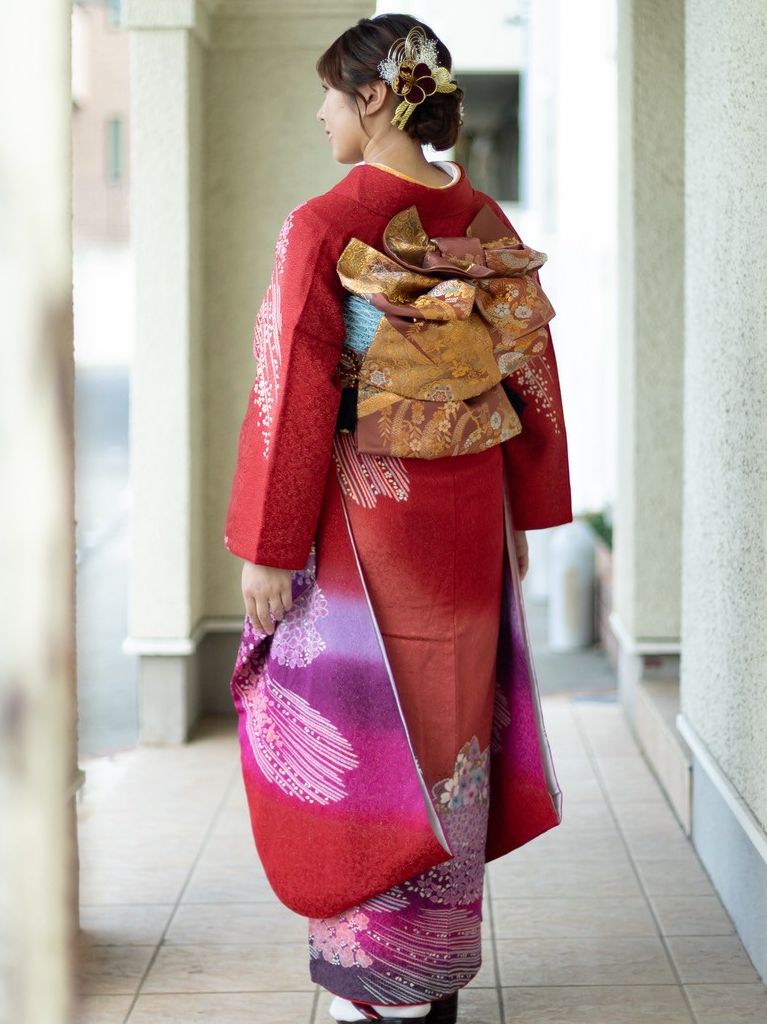 赤の振袖に金糸の帯帯結びは羽のある華やかなお太鼓結び。