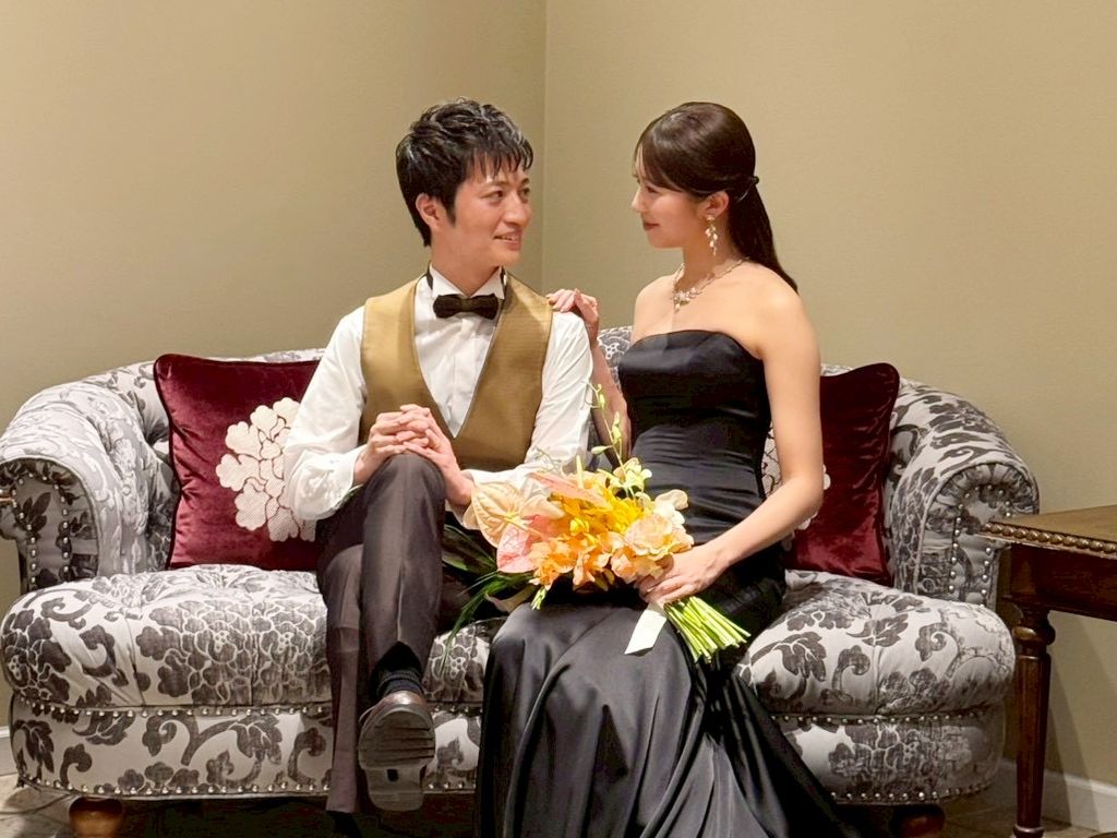 披露宴後にソファーでリラックスした時間を過ごす、笑顔の新郎新婦。